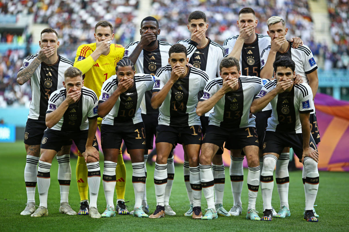 The German national team pictured posing for a team photo with their hands covering their mouths at the FIFA World Cup in Qatar