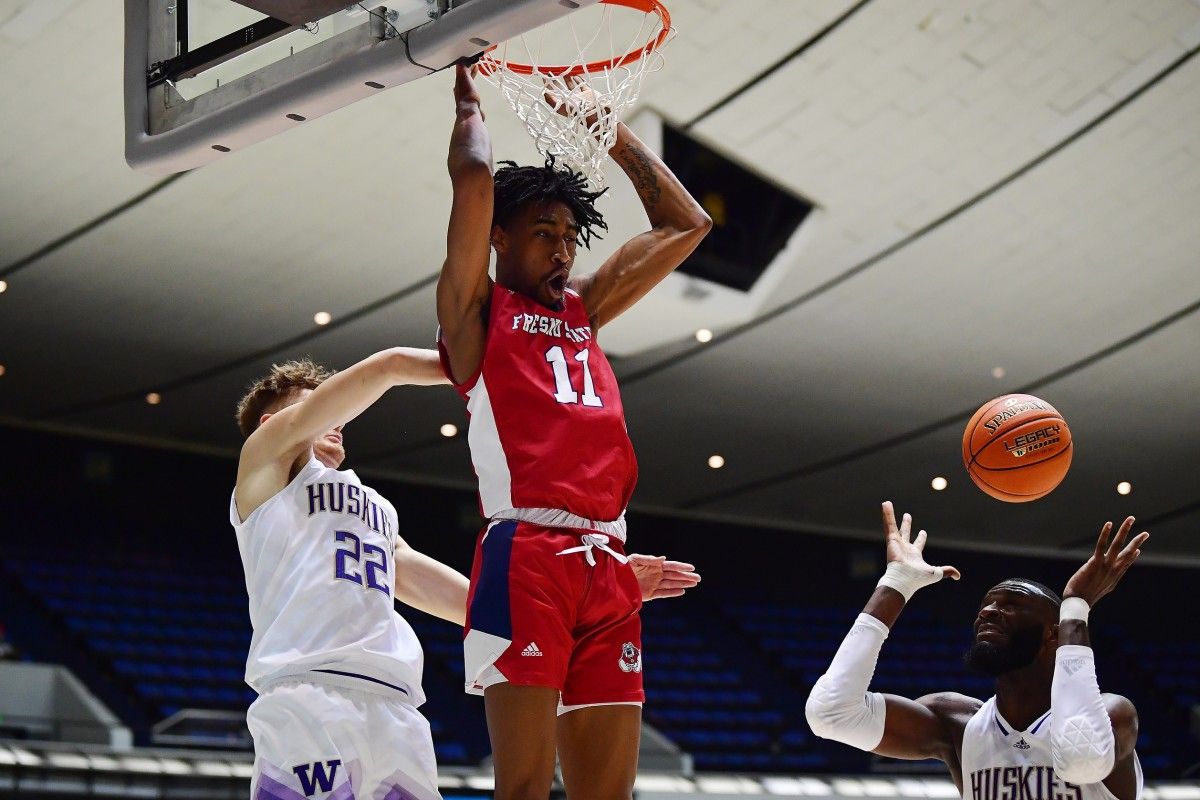 Eduardo Andre dunks over the UW's Cole Bajema and Franck Kepnang.