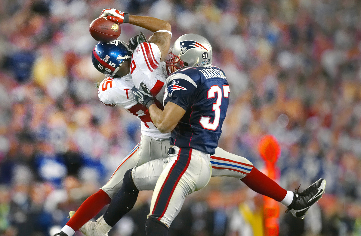 David Tyree catches a pass as a Patriots defender grabs him to tackle
