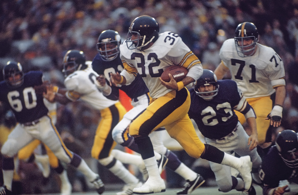 Franco Harris runs with the ball in one hand
