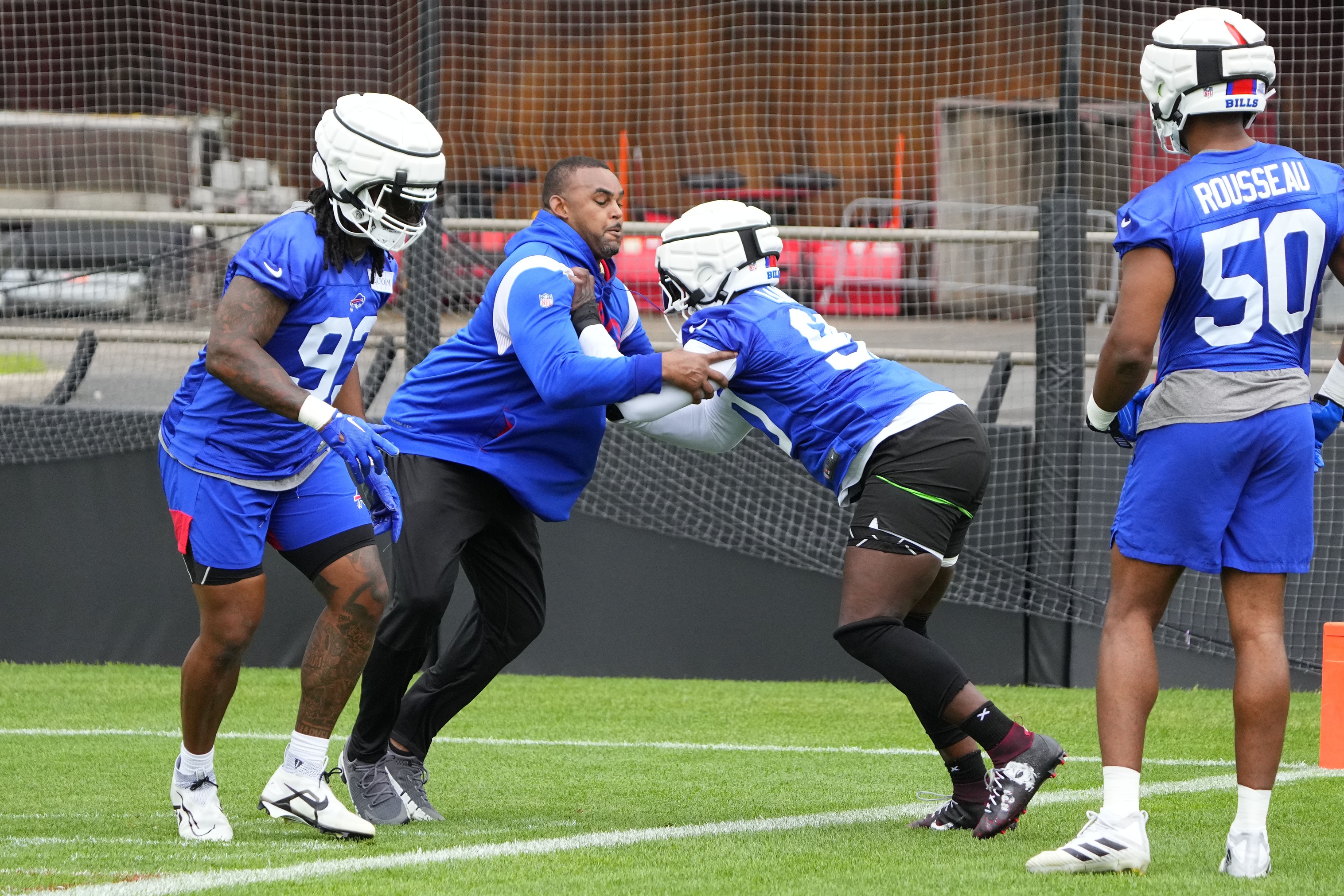 Jul 27, 2023; Rochester NY, USA; Buffalo Bills defensive end Shaq Lawson (90) blocks with assistant defensive line coach Marcus West during training camp at St. John Fisher College.