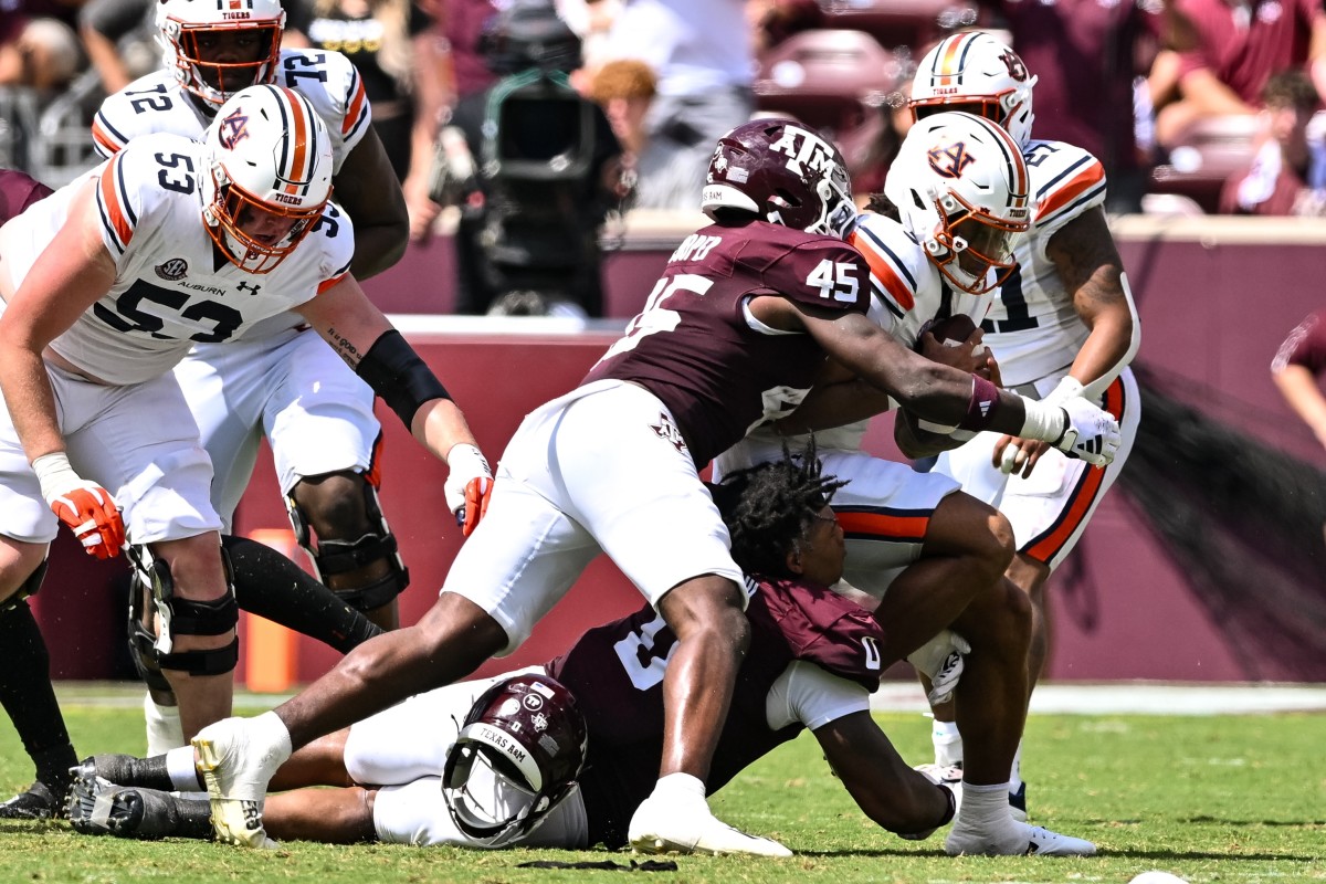 Sep 23, 2023; College Station, Texas, USA; Texas A&M Aggies defensive lineman Walter Nolen (0) and linebacker Edgerrin Cooper (45) tackle Auburn Tigers quarterback Robby Ashford (9) for a loss during the third quarter at Kyle Field. Mandatory Credit: Maria Lysaker-USA TODAY Sports  