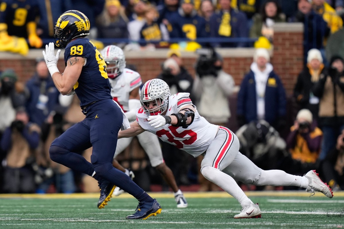 Nov 25, 2023; Ann Arbor, Michigan, USA; Ohio State Buckeyes linebacker Tommy Eichenberg (35) tries to make a tackle on Michigan Wolverines tight end AJ Barner (89) during the second half of the NCAA football game at Michigan Stadium. Ohio State lost 30-24.  