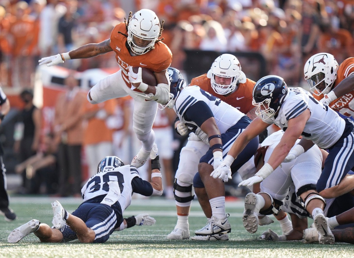Texas Longhorns running back Jonathon Brooks jumps over BYU Cougars safety Crew Wakley in the third quarter at Royal-Memorial Stadium on Saturday October 28, 2023.  