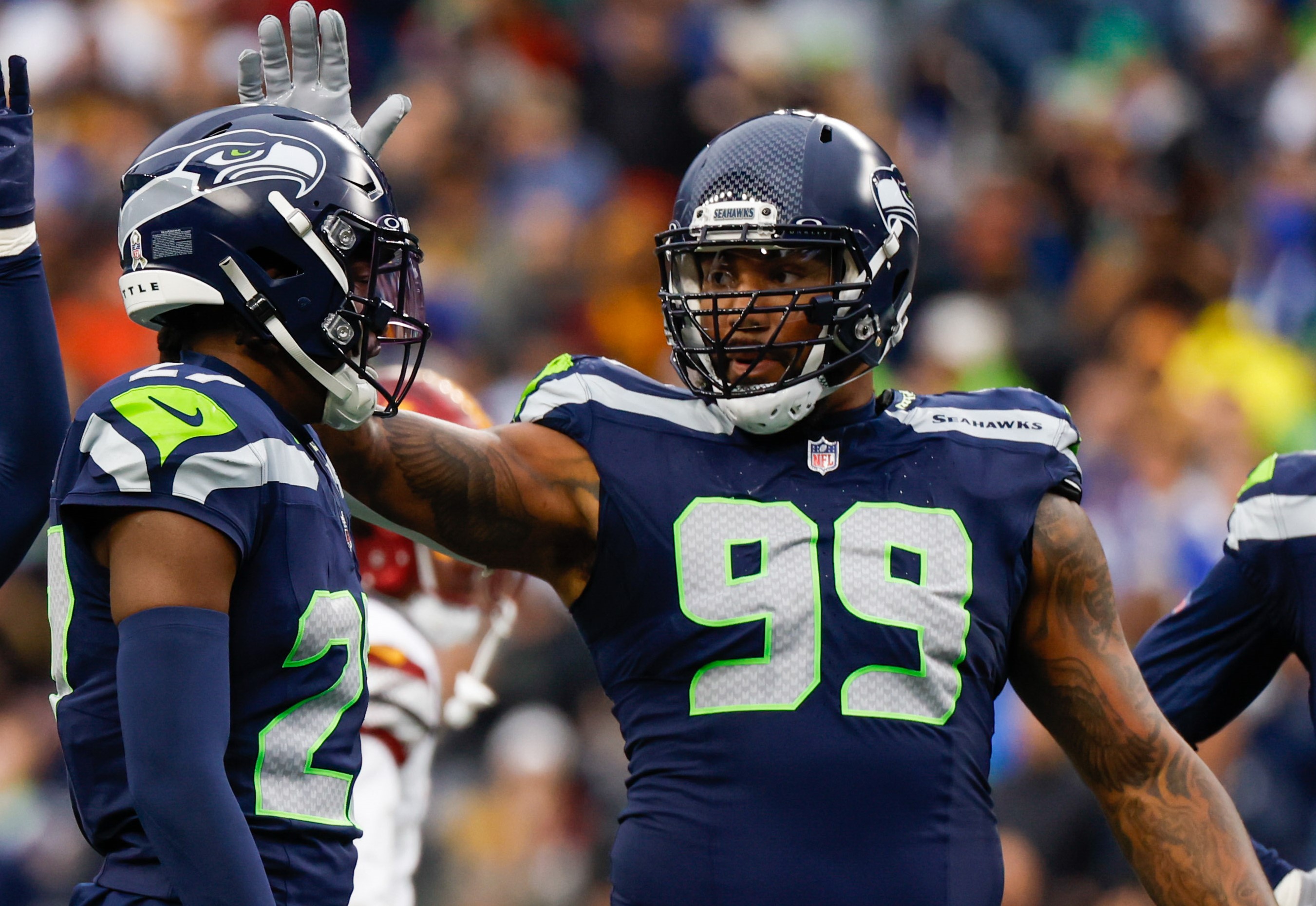 Seattle Seahawks cornerback Riq Woolen (27) and defensive end Leonard Williams (99) celebrate following a play against the Washington Commanders during the second quarter at Lumen Field.