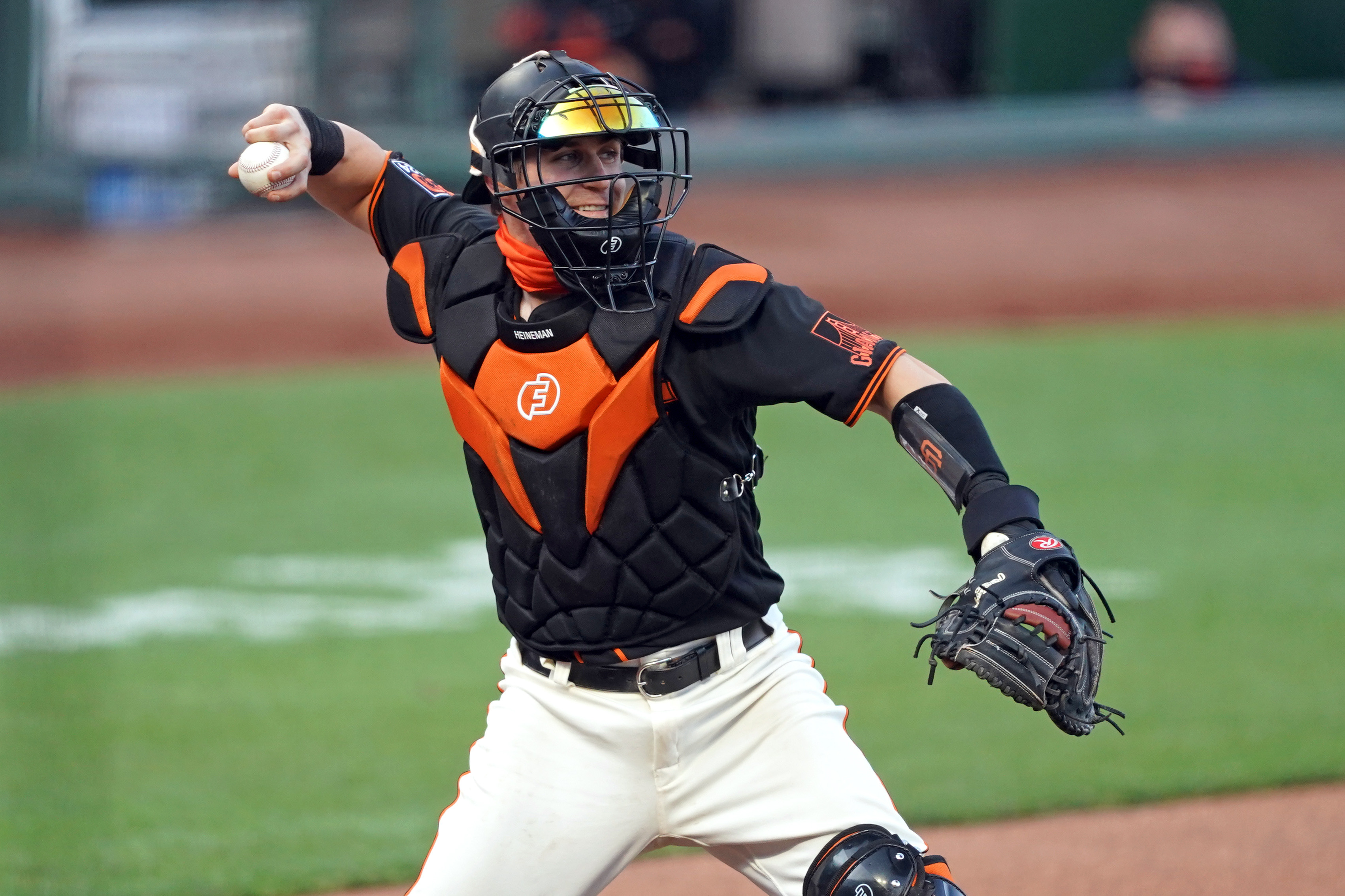 SF Giants catcher Tyler Heineman throws the ball to first base to complete a strikeout during the second inning against the Texas Rangers at Oracle Park. (2020)