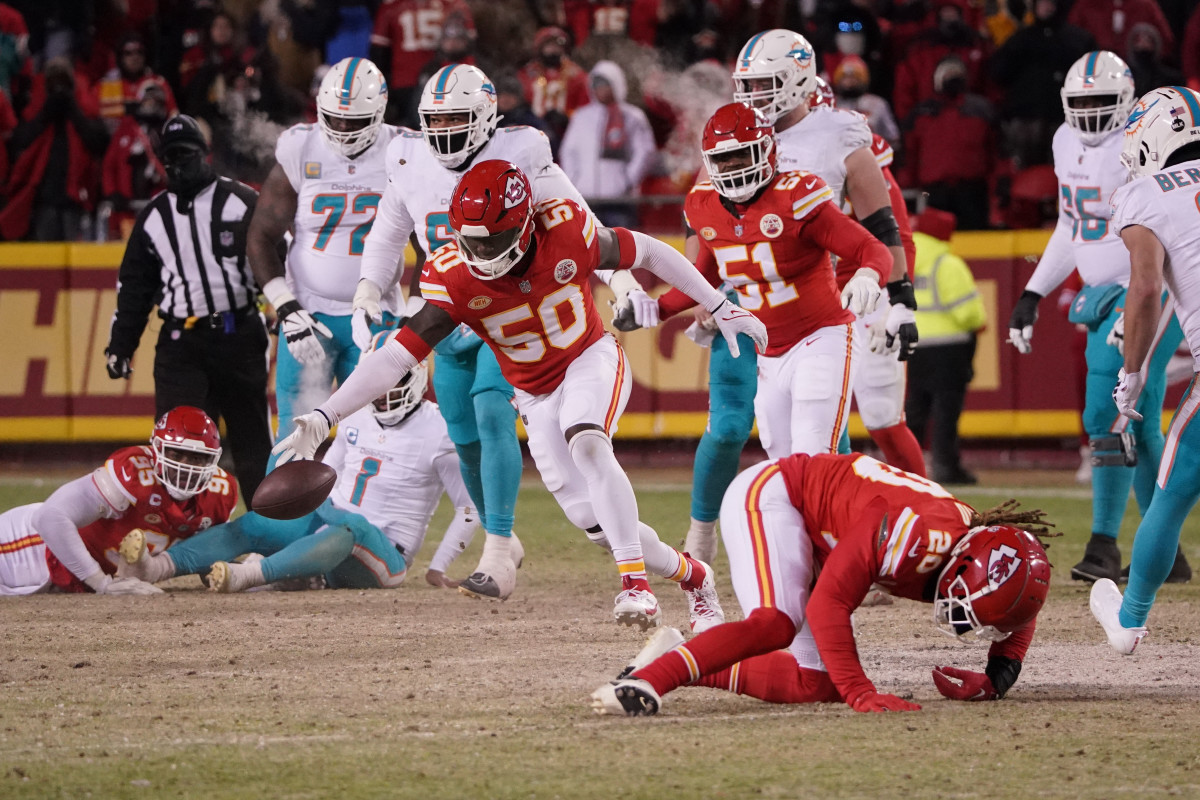 Willie Gay runs to recover a fumble ball as Chiefs and Dolphins players gather around him