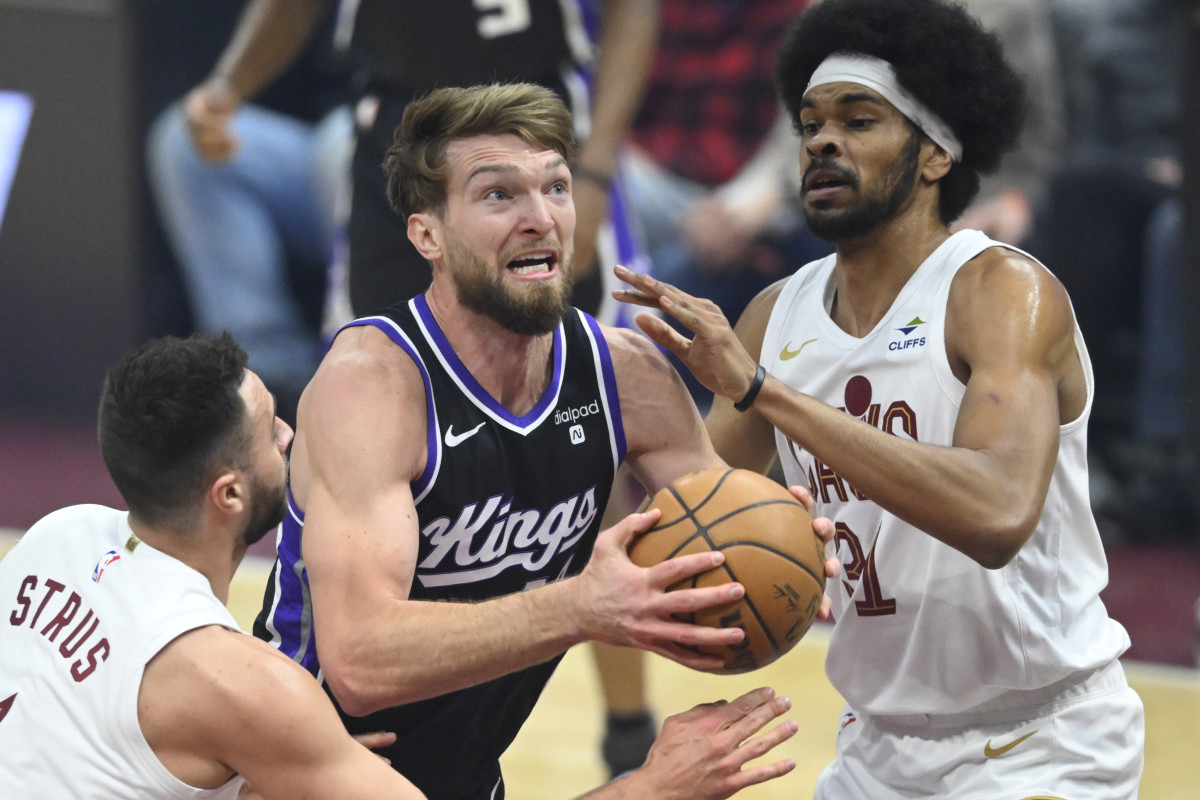 Feb 5, 2024; Cleveland, Ohio, USA; Sacramento Kings forward Domantas Sabonis (10) drives between Cleveland Cavaliers guard Max Strus (1) and center Jarrett Allen (31) in the first quarter at Rocket Mortgage FieldHouse.