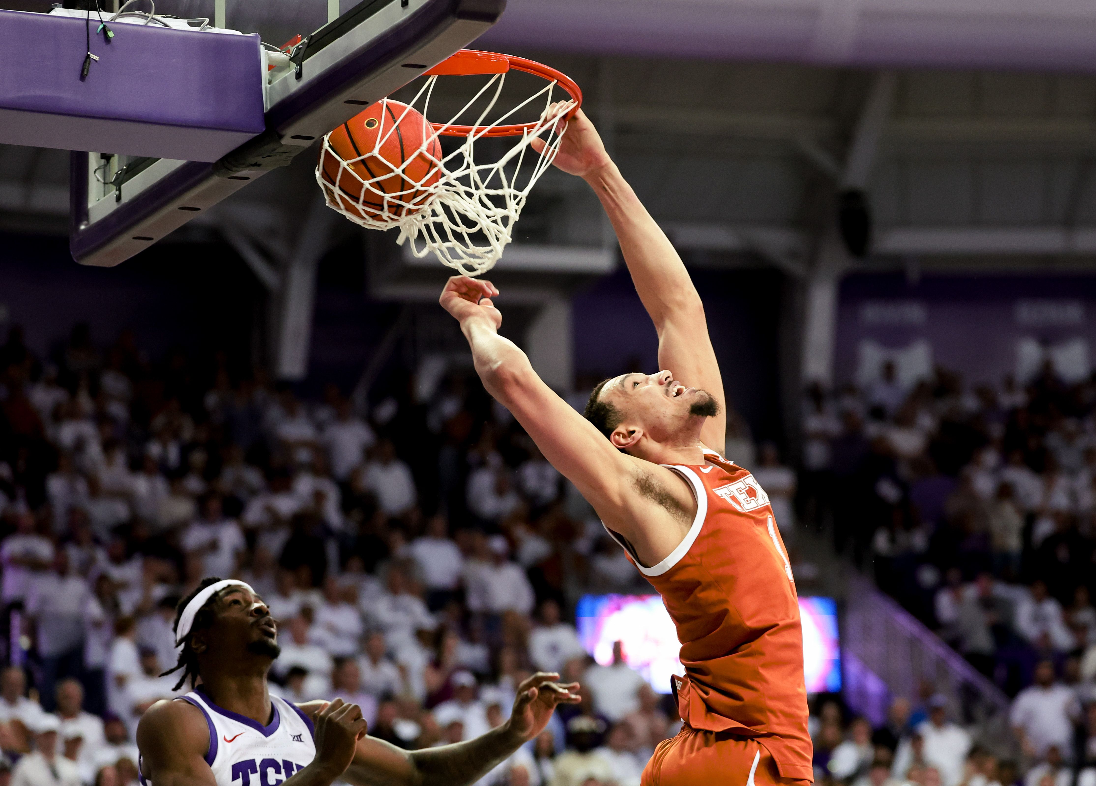 Texas Longhorns forward Dylan Disu (1) dunks past TCU Horned Frogs forward Emanuel Miller (2) during the second half at Ed and Rae Schollmaier Arena.