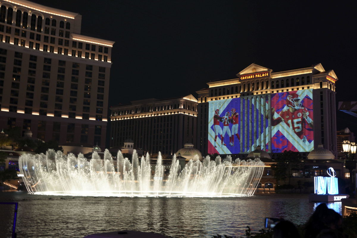 Caesar’s Palace in Las Vegas is illuminated with Super Bowl graphics with a fountain in front