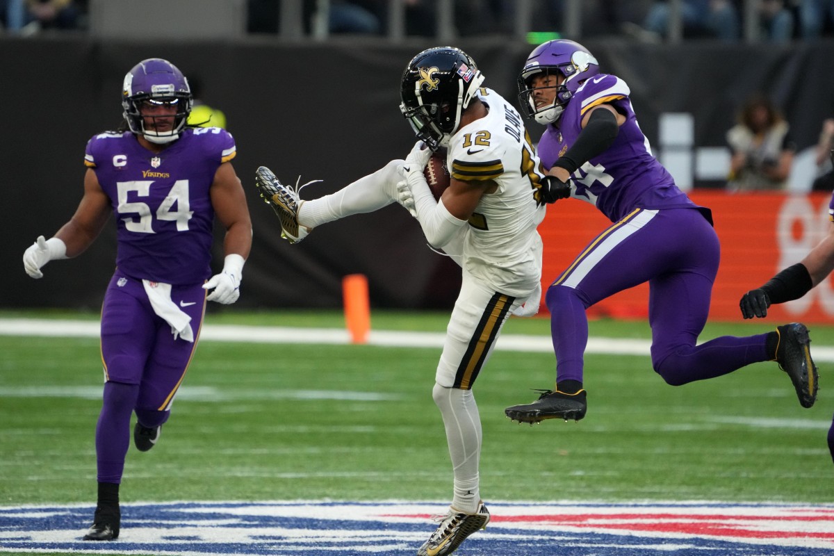Oct 2, 2022; London, United Kingdom; New Orleans Saints receiver Chris Olave (12) catches a pass between Minnesota Vikings safety Camryn Bynum (24) and linebacker Eric Kendricks (54) during an NFL International Series game at Tottenham Hotspur Stadium. Mandatory Credit: Kirby Lee-USA TODAY Sports