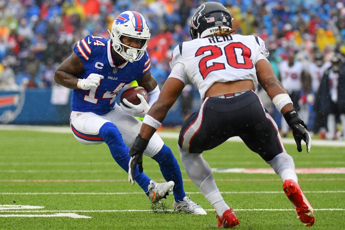 Oct 3, 2021; Orchard Park, New York, USA; Buffalo Bills wide receiver Stefon Diggs (14) runs with the ball as Houston Texans strong safety Justin Reid (20) defends during the second half at Highmark Stadium.