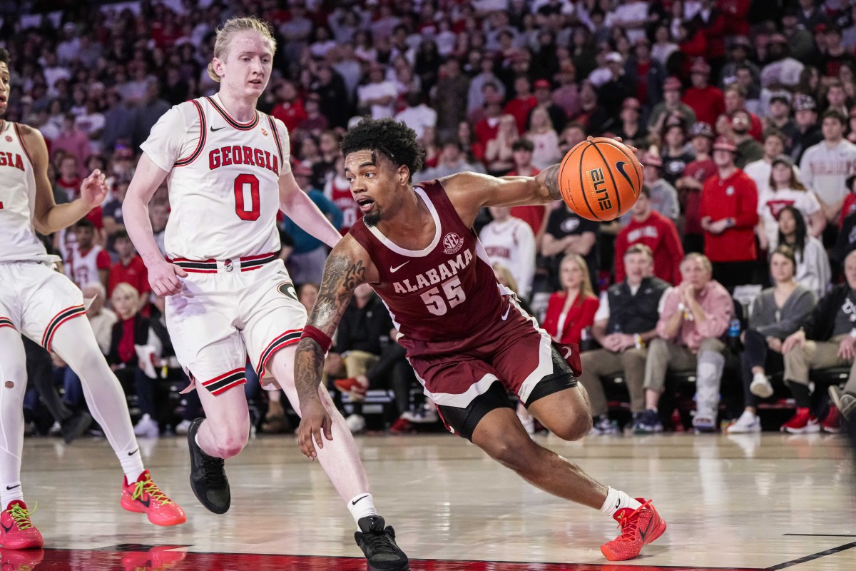 Alabama Crimson Tide guard Aaron Estrada dribbles past Georgia Bulldogs guard Blue Cain.