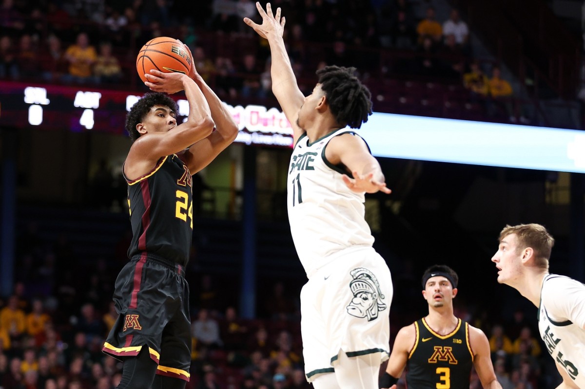 Feb 6, 2024; Minneapolis, Minnesota, USA; Minnesota Golden Gophers guard Cam Christie (24) shoots as Michigan State Spartans guard A.J. Hoggard (11) defends during the first half at Williams Arena.