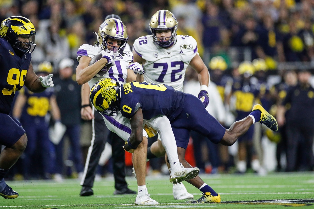 Michigan defensive back Mike Sainristil tackles Washington wide receiver Jalen McMillan during the second half of U-M's 34-13 win in the College Football Playoff national championship game in Houston on Monday, Jan. 8, 2024.  