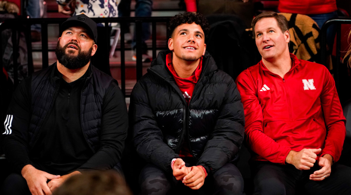 Nebraska quarterback commit Dylan Raiola (center) sits with his uncle, offensive line coach Donovan Raiola and athletic director Trev Alberts at a Huskers basketball game.