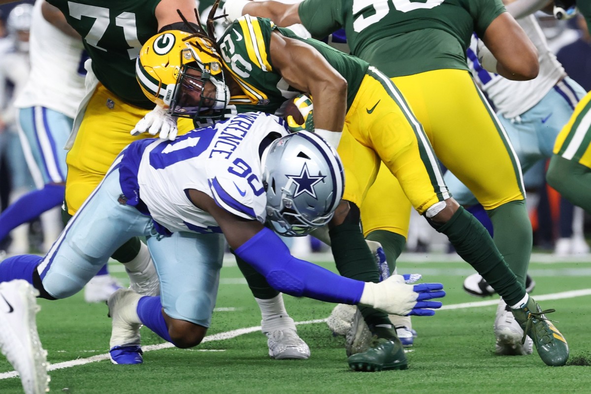 Jan 14, 2024; Arlington, Texas, USA; Dallas Cowboys defensive end DeMarcus Lawrence (90) tackles Green Bay Packers running back Aaron Jones (33) during the first quarter for the 2024 NFC wild card game at AT&T Stadium.