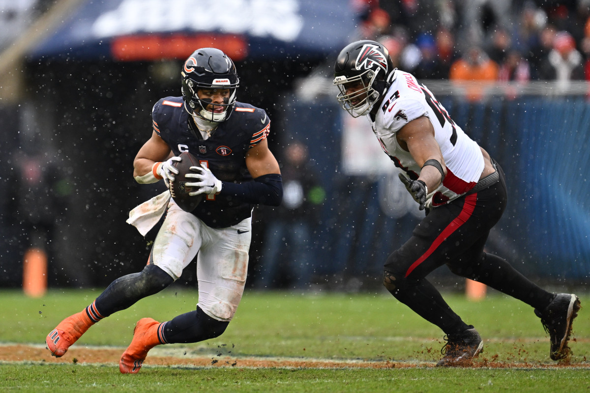 Dec 31, 2023; Chicago, Illinois, USA; Chicago Bears quarterback Justin Fields (1) scrambles away from Atlanta Falcons defensive lineman Calais Campbell (93) in the first half at Soldier Field. 
