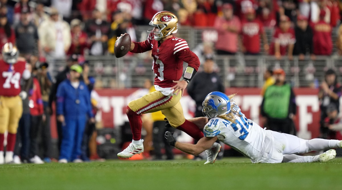 San Francisco 49ers quarterback Brock Purdy (13) runs with the ball against Detroit Lions linebacker Alex Anzalone during the NFC championship game.