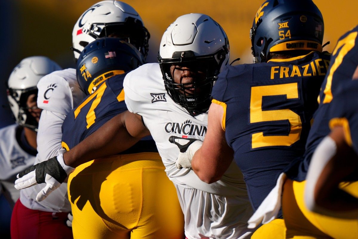 Cincinnati Bearcats defensive lineman Dontay Corleone (2) rushes the quarterback as West Virginia Mountaineers offensive lineman Zach Frazier (54) blocks in the first quarter during an NCAA college football game between the Cincinnati Bearcats and the West Virginia Mountaineers, Saturday, Nov. 18, 2023, at Milan Puskar Stadium in Morgantown, W. Va.  