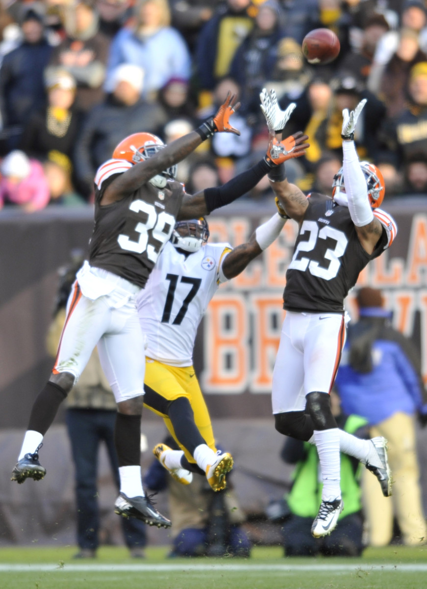 Nov 25, 2012; Cleveland, OH, USA; Cleveland Browns cornerback Joe Haden (23) intercepts a pass intended for Pittsburgh Steelers wide receiver Mike Wallace (17) in the fourth quarter at Cleveland Browns Stadium. Cornerback Tashaun Gipson (39) is also in on the play. Mandatory Credit: David Richard-USA TODAY Sports  
