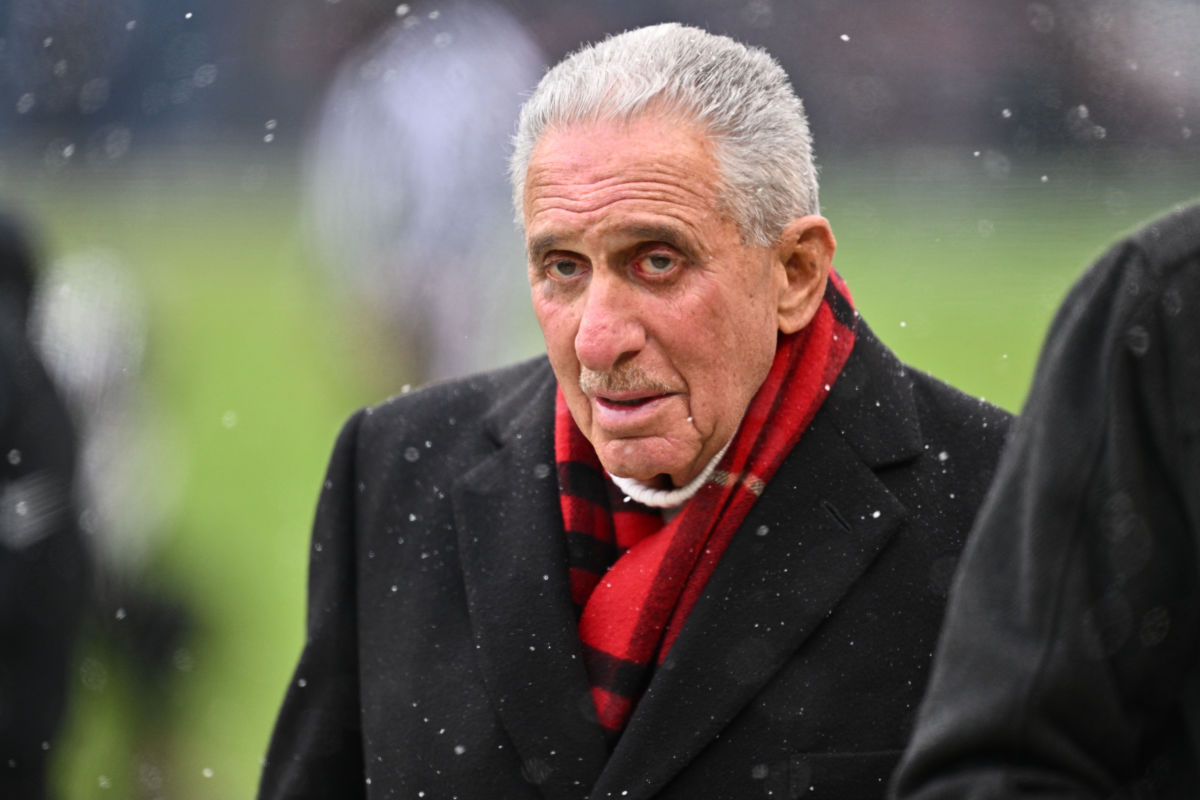 Arthur Blank wears a scarf amid snow on the field