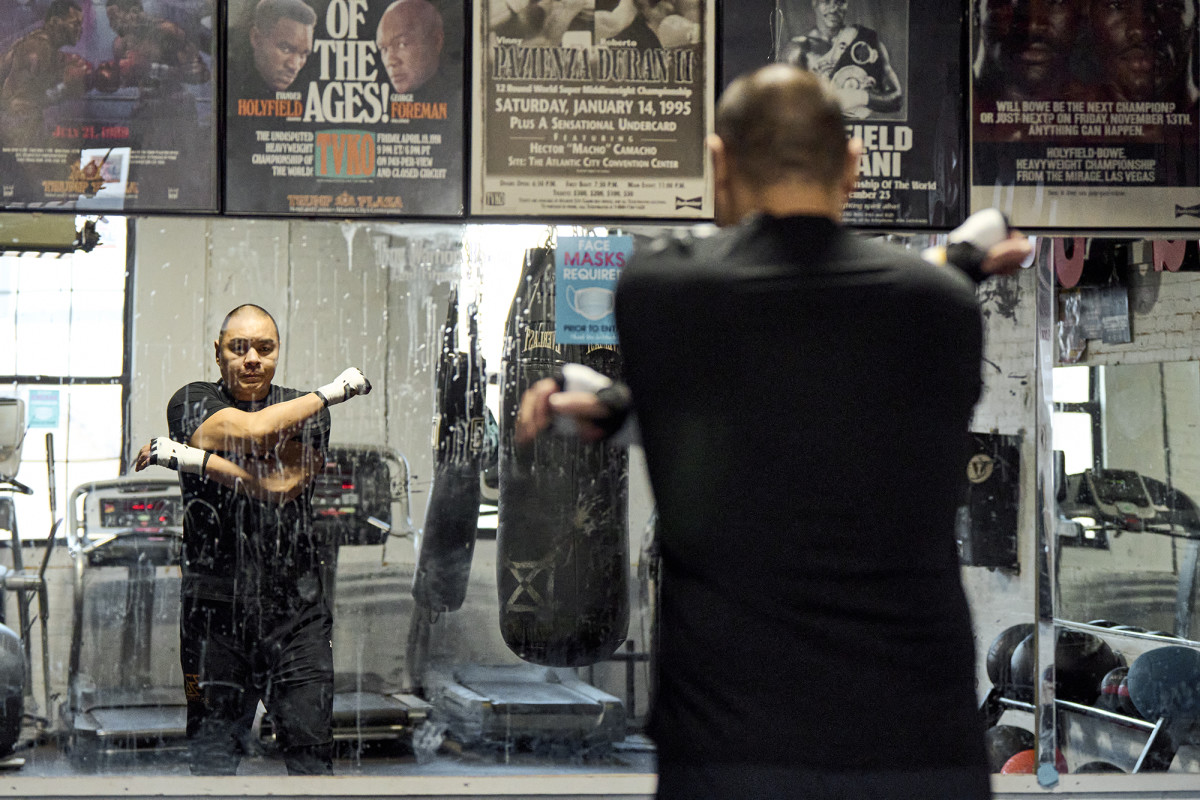Boxer Zhilei Zhang looks at himself in the mirror at a gym while training.