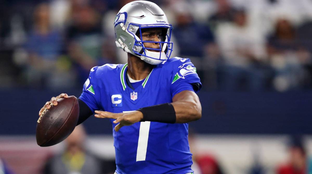 Seahawks quarterback Geno Smith drops back to throw a pass in a game.