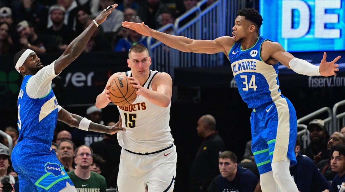 Denver Nuggets center Nikola Jokic (15) is pressured by Milwaukee Bucks forward Bobby Portis (9) and forward Giannis Antetokounmpo (34) in the second quarter at Fiserv Forum in Milwaukee on Feb. 12, 2024.