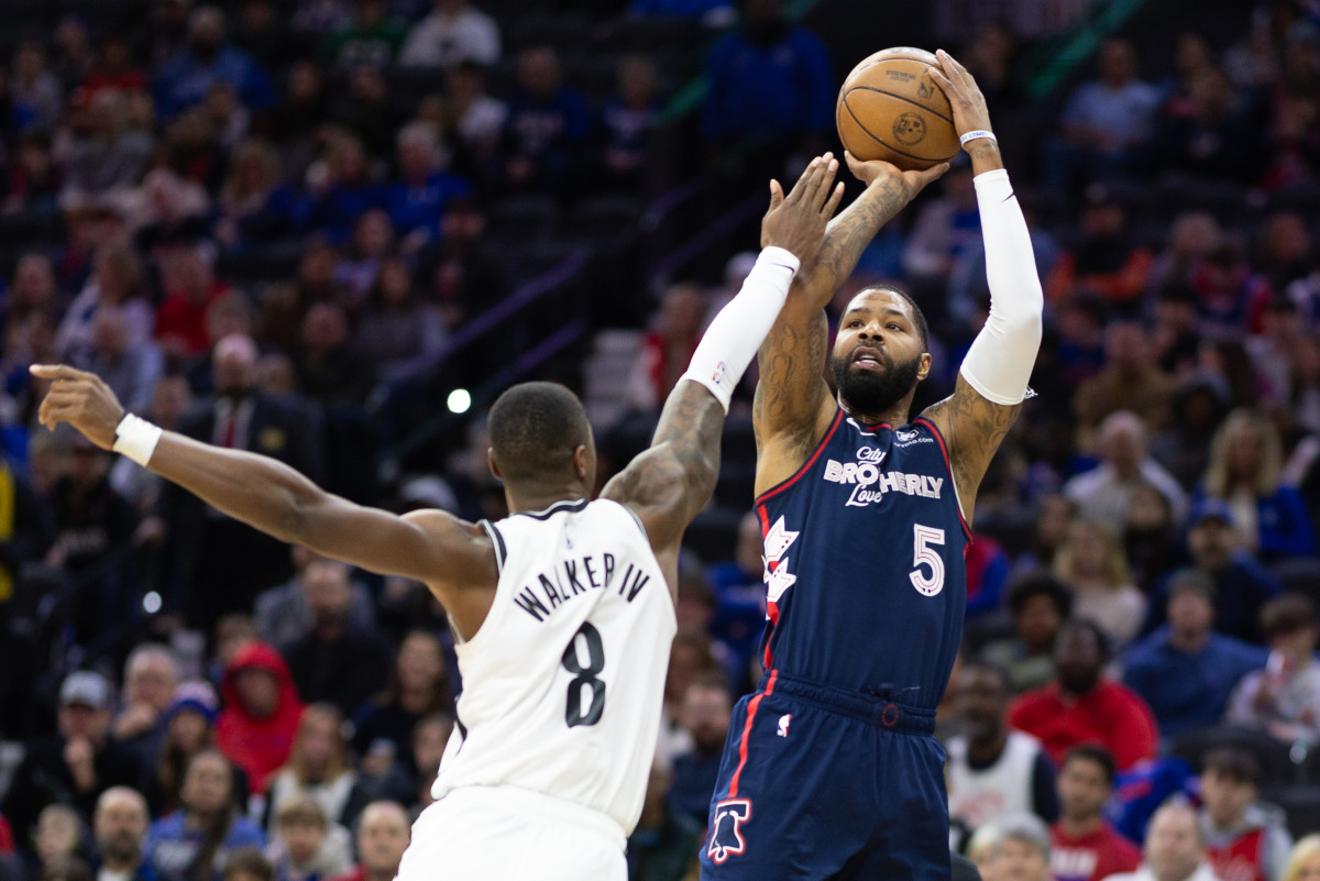 Feb 3, 2024; Philadelphia, Pennsylvania, USA; Philadelphia 76ers forward Marcus Morris Sr. (5) shoots the ball past Brooklyn Nets guard Lonnie Walker IV (8) during the first quarter at Wells Fargo Center.