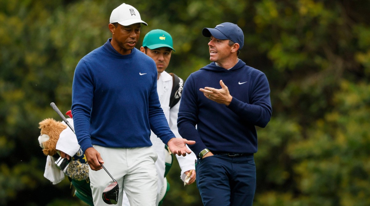Tiger Woods and Rory McIlroy talk as they walk down the 11th fairway during their practice round for the 2023 Masters Tournament at Augusta National Golf Club.