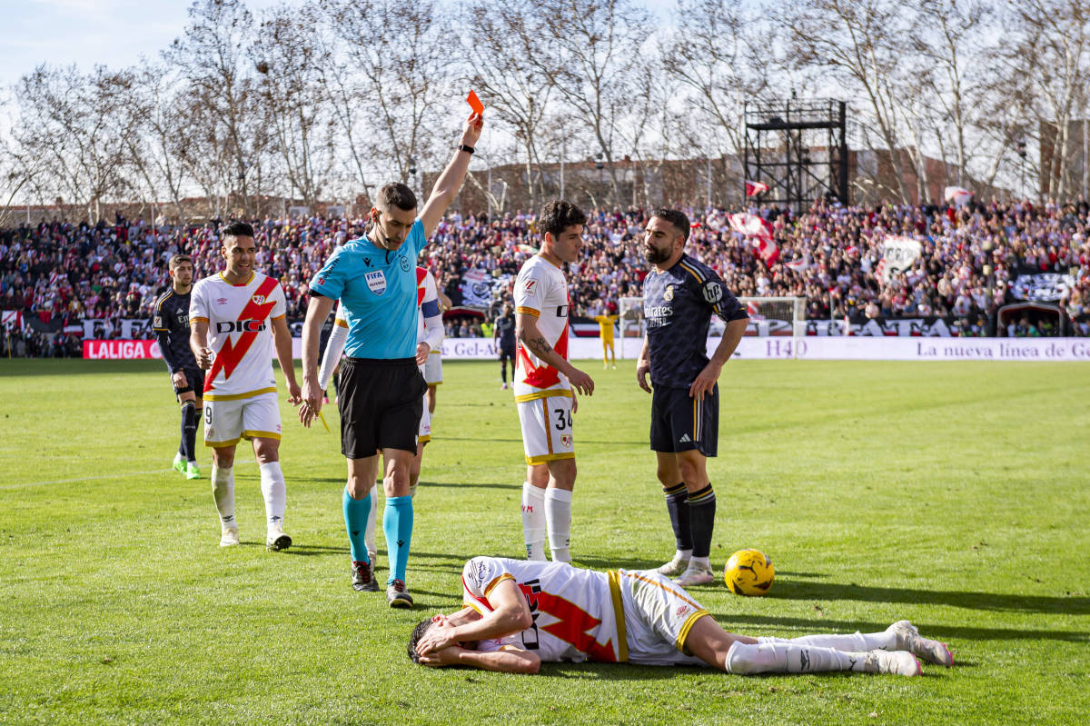 Referee Alejandro Muniz pictured showing a red card to Dani Carvajal (right) after the Real Madrid defender lashed out at Rayo Vallecano midfielder Kike Perez (bottom) during a La Liga game in February 2024