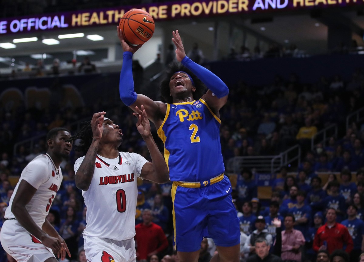 Pittsburgh Panthers Blake Hinson (2) goes for two points after tripping up Louisville Cardinals Mike James (0) during the first half on Feb. 17, 2024, at the Petersen Events Center in Pittsburgh.