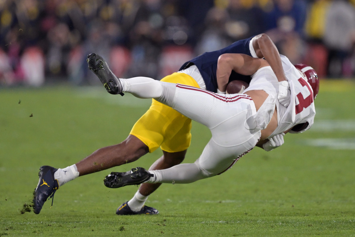 Michigan Wolverines safety Keon Sabb tackles Alabama Crimson Tide wide receiver Jermaine Burton during the 2024 Rose Bowl in Pasadena, California.