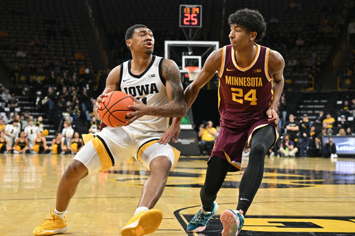 Feb 11, 2024; Iowa City, Iowa, USA; Iowa Hawkeyes guard Tony Perkins (11) goes to the basket as Minnesota Golden Gophers guard Cam Christie (24) defends during the second half at Carver-Hawkeye Arena.