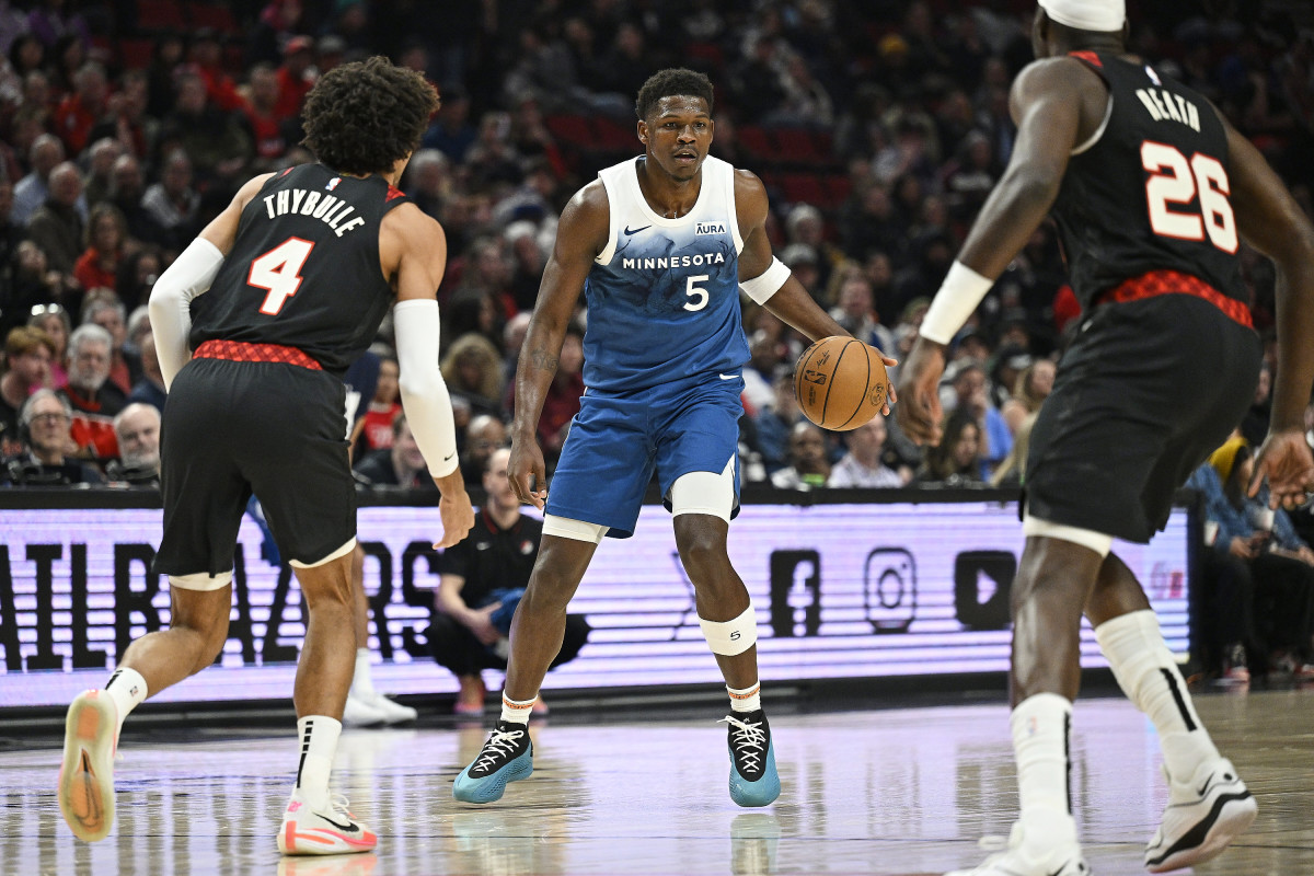 Feb 15, 2024; Portland, Oregon, USA; Minnesota Timberwolves guard Anthony Edwards (5) dribbles the ball during the first half against Portland Trail Blazers guard Matisse Thybulle (4) and center Duop Reath (26) at Moda Center.