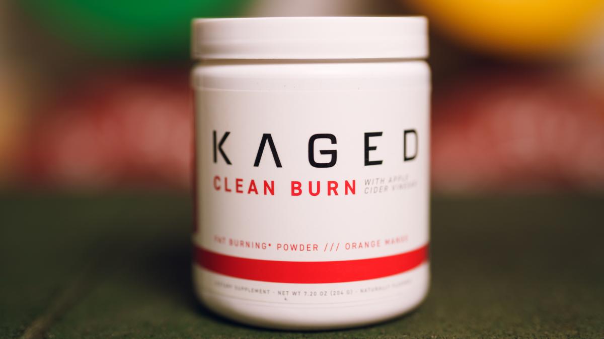 A blurred background with a red and white container of Kaged Clean Burn with ACV in the foreground