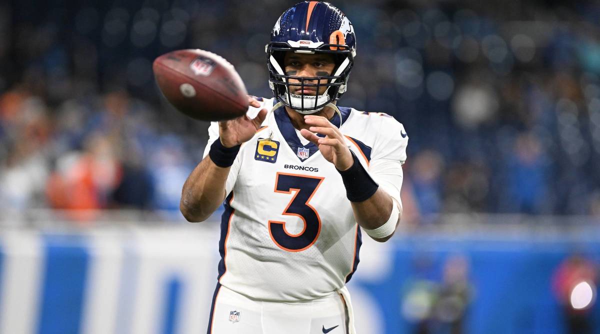 Broncos quarterback Russell Wilson catches a football during warmups before a game.