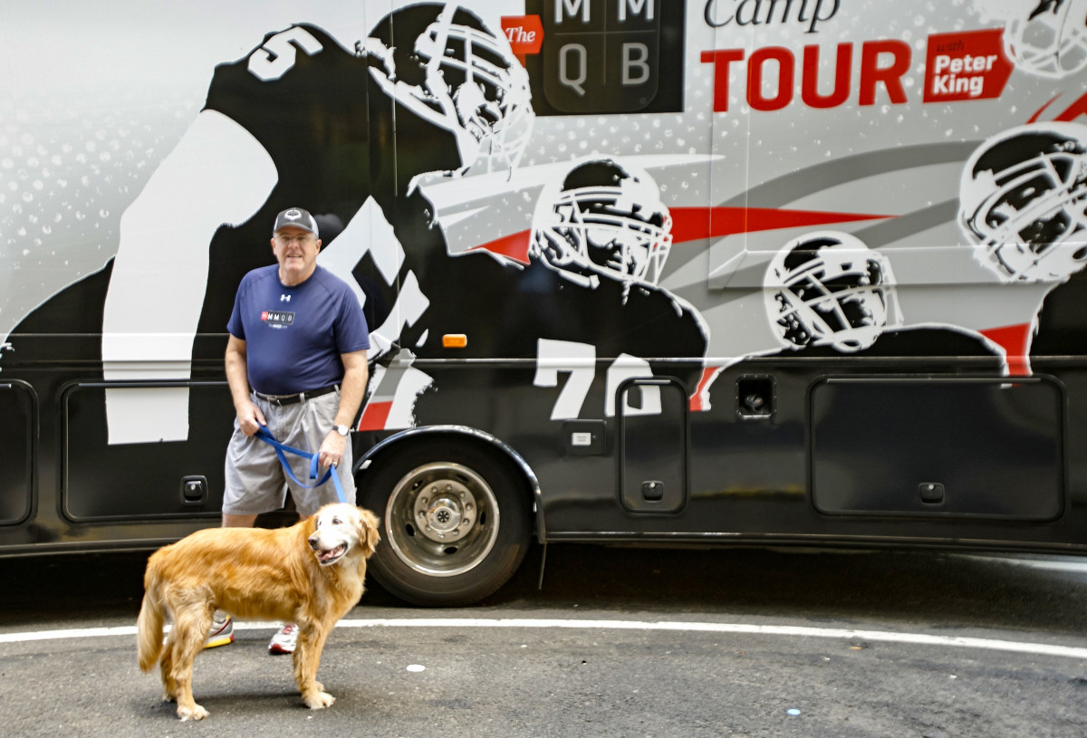 Peter King and his dog pose in front of the MMQB Camp Tour truck