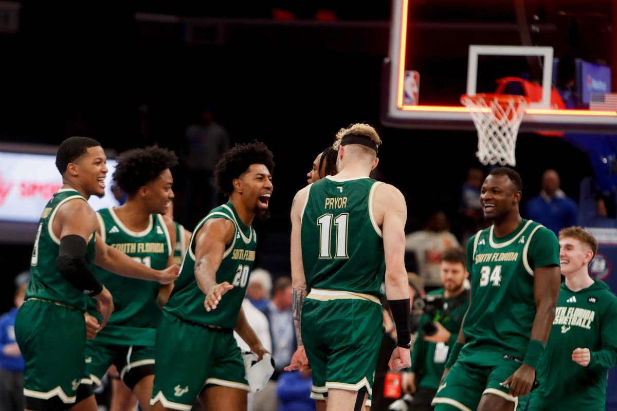 South Florida Bulls forward Sam Hines Jr. (20) slaps forward Kasean Pryor (11) on the back as the team celebrates as the buzzer sounds after defeating Memphis 74-73 at FedExForum in Memphis, Tennessee, on Jan. 18, 2024.