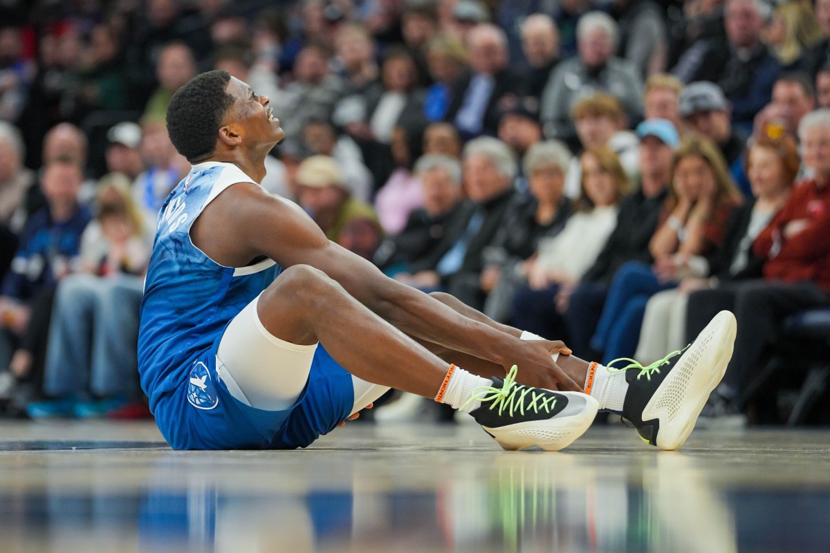 Feb 27, 2024; Minneapolis, Minnesota, USA; Minnesota Timberwolves guard Anthony Edwards (5) holds his ankle on the ground against the San Antonio Spurs in the second quarter at Target Center.