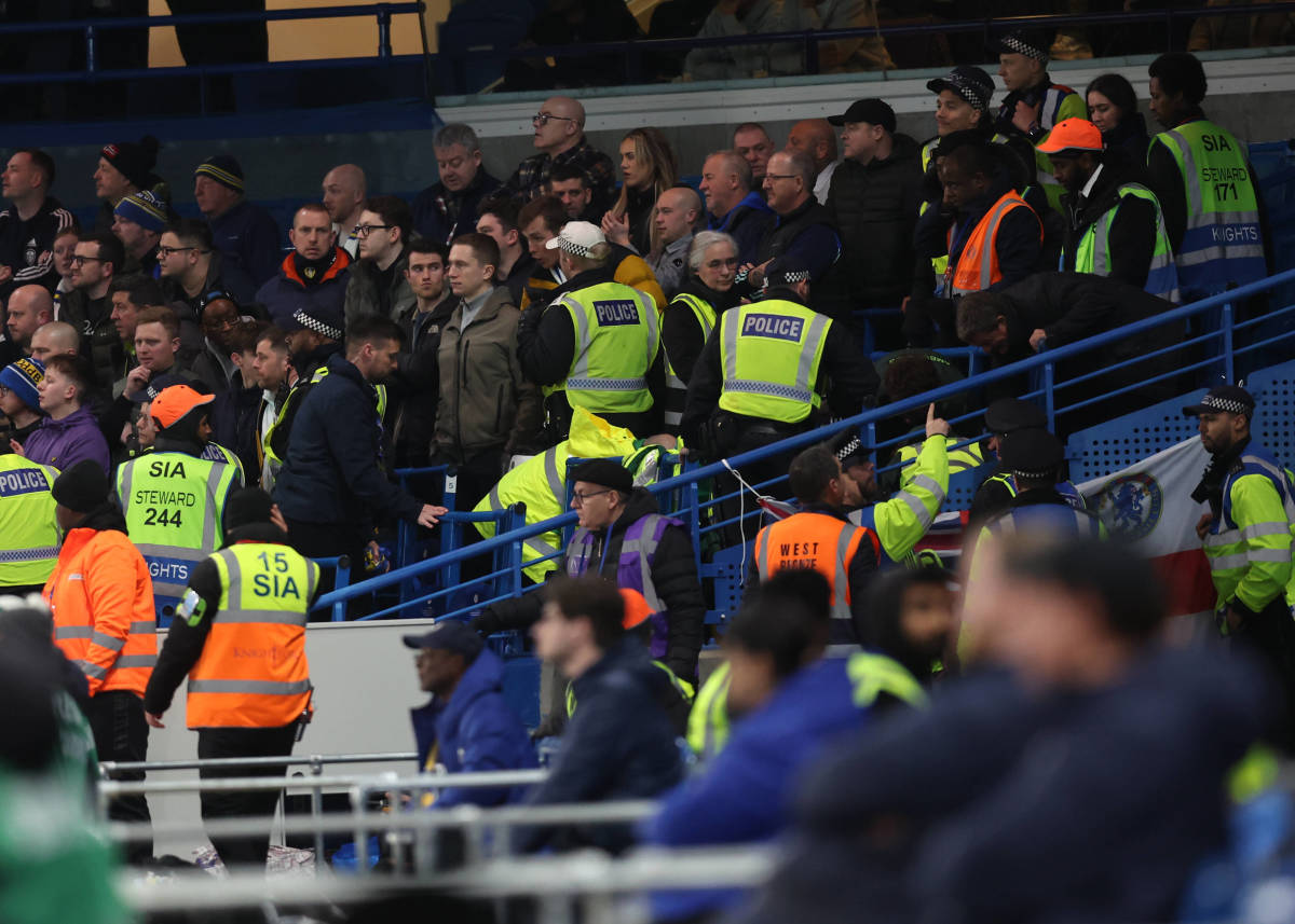 Stewards, police officers and medical staff pictured in the away end at Chelsea's Stamford Bridge after a Leeds United fan fell from the upper tier during an FA Cup game in February 2024