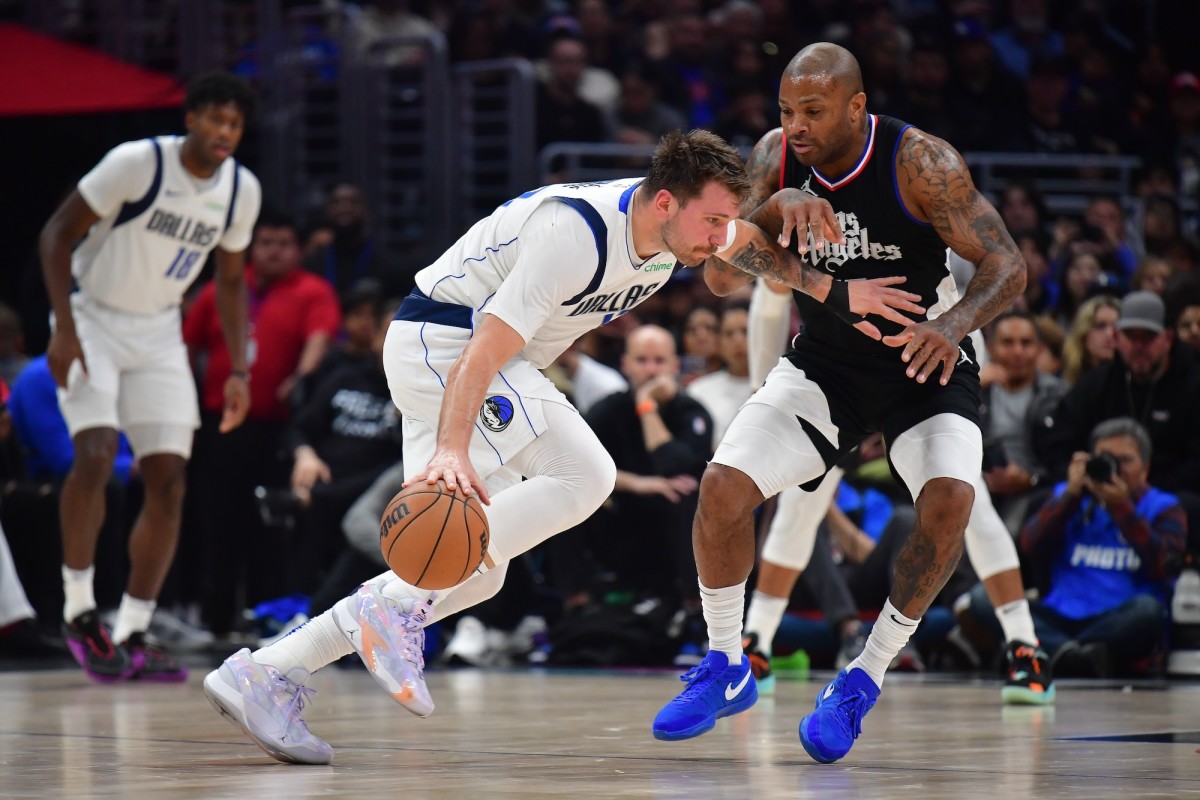 Dallas Mavericks guard Luka Doncic (77) moves the ball against Los Angeles Clippers forward P.J. Tucker (17) during the first half at Crypto.com Arena in Los Angeles, California, on Nov. 25, 2023.