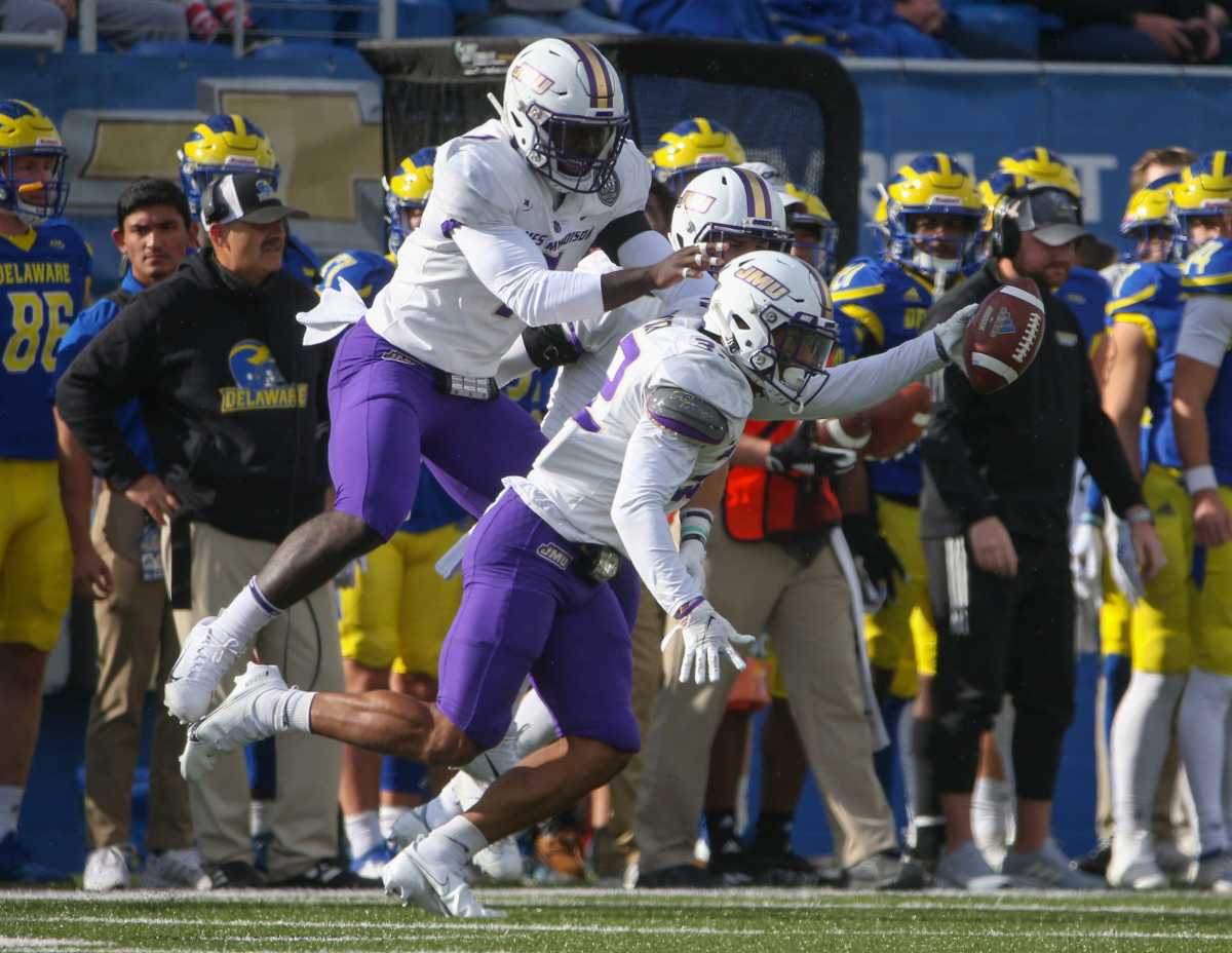 James Madison's MJ Hampton (right) is the center of celebration after intercepting a pass in the first quarter at Delaware Stadium on Saturday, Oct. 23, 2021.