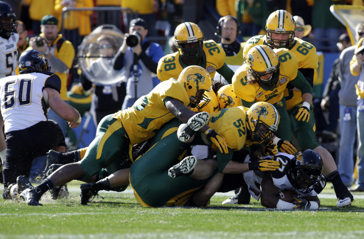 Jan 4, 2014; Frisco, TX, USA; Towson Tigers running back Darius Victor (27) is tackled by North Dakota State Bison linebacker Travis Beck (52) and his teammates in the first quarter at Toyota Stadium.