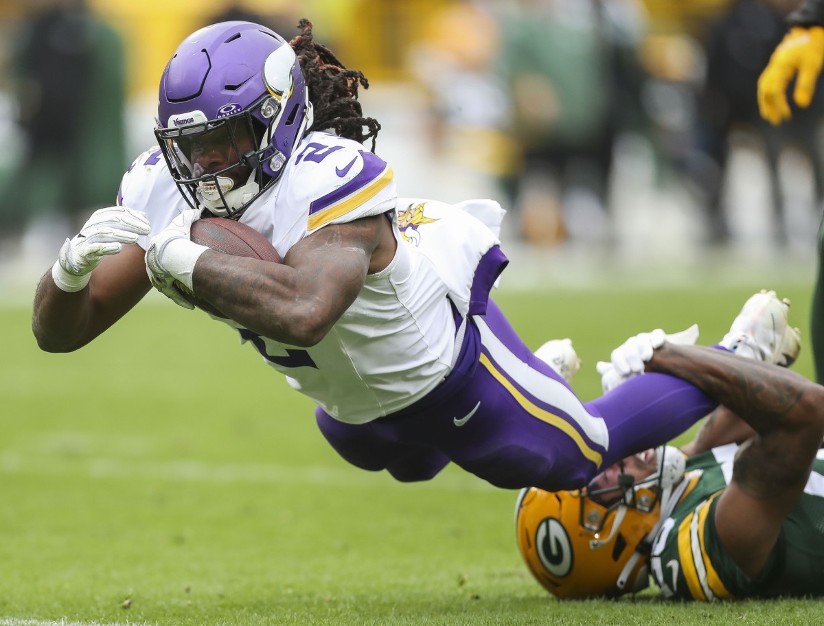 Oct 29, 2023; Green Bay, Wisconsin, USA; Minnesota Vikings running back Alexander Mattison (2) dives forward for extra yardage against the Green Bay Packers in the game at Lambeau Field. 