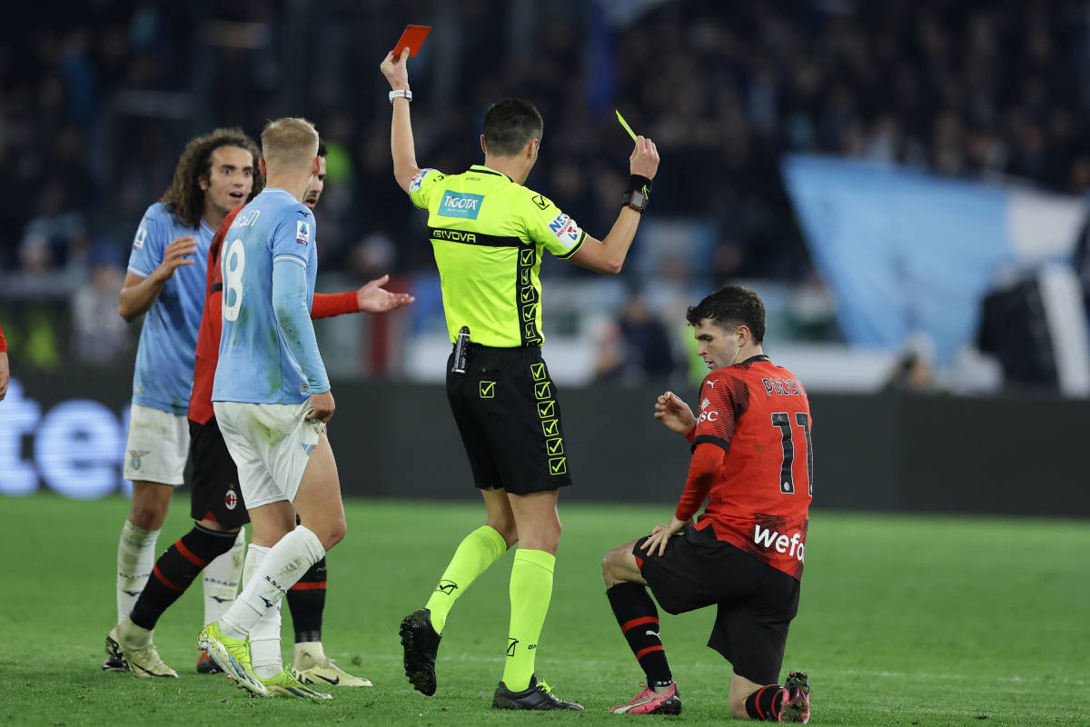 Referee Marco Di Bello pictured showing a red card to Lazio midfielder Matteo Guendouzi (left) and a yellow card to AC Milan forward Christian Pulisic (right) during a Serie A game in March 2024