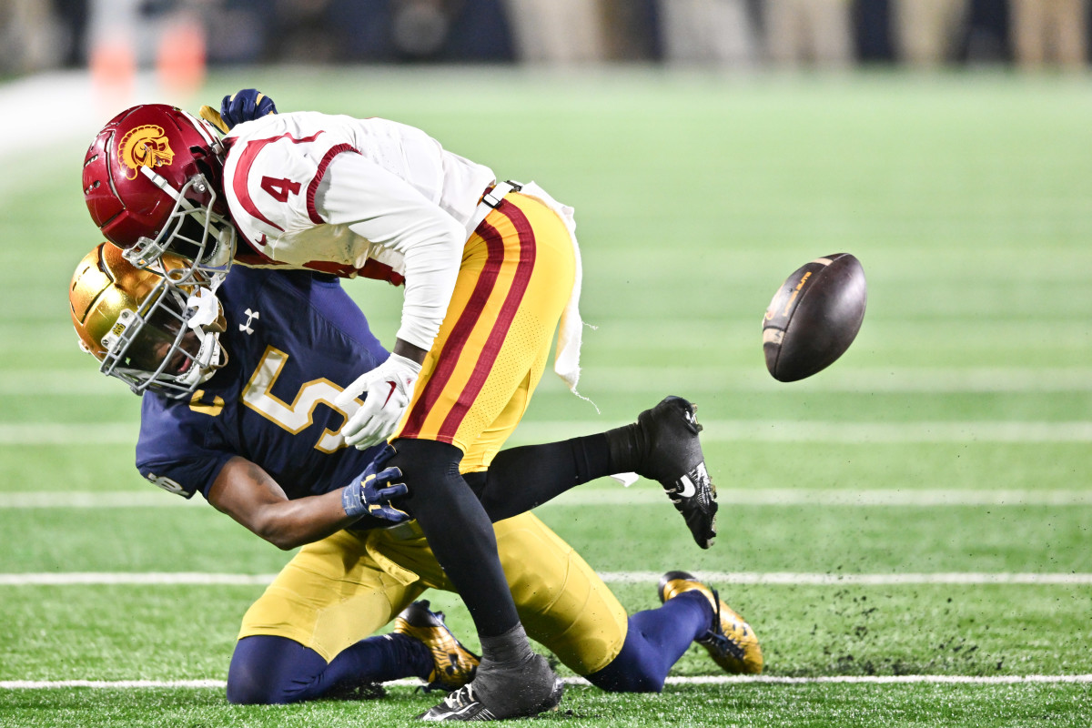 Oct 14, 2023; South Bend, Indiana, USA; USC Trojans wide receiver Mario Williams (4) loses the ball as he is hit by Notre Dame Fighting Irish cornerback Cam Hart (5) in the fourth quarter at Notre Dame Stadium. Notre Dame won 48-20. Mandatory Credit: Matt Cashore-USA TODAY Sports