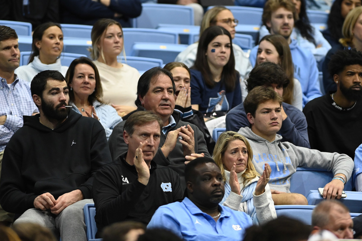 Luke Maye, Mark Maye and Drake Maye sit in the stadium at a UNC basketball game