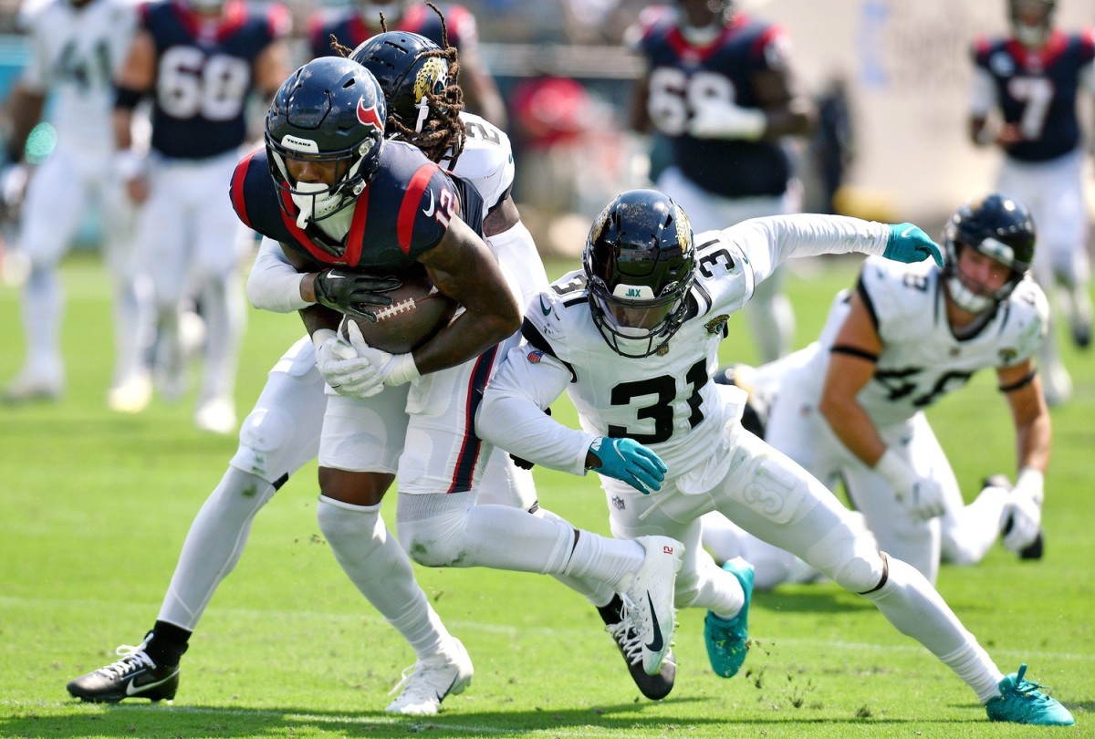Jacksonville Jaguars safety Rayshawn Jenkins (2) and cornerback Darious Williams (31) try to slow down Houston Texans wide receiver Nico Collins (12) as he runs for a first down late in the second quarter. The Jacksonville Jaguars hosted the Houston Texans at EverBank Stadium in Jacksonville, Fla. Sunday, September 24, 2023. The Jaguars trailed 17 to 0 at the end of the first half.